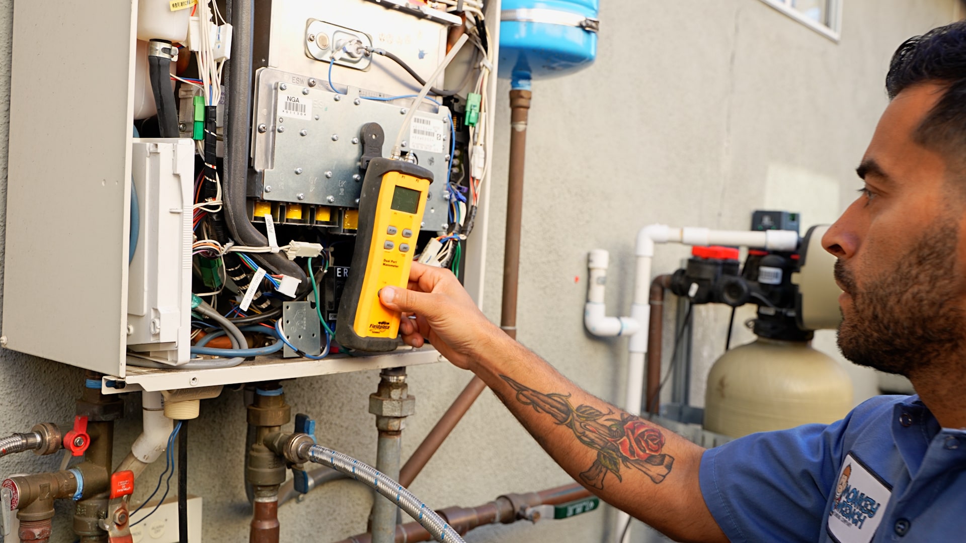 Technician performing tankless water heater maintenance outside of home