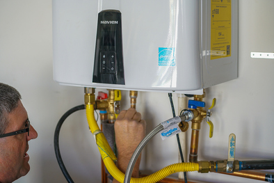 A technician working on a tankless water heater