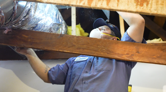 A technician applies hardware cloth on ductwork.