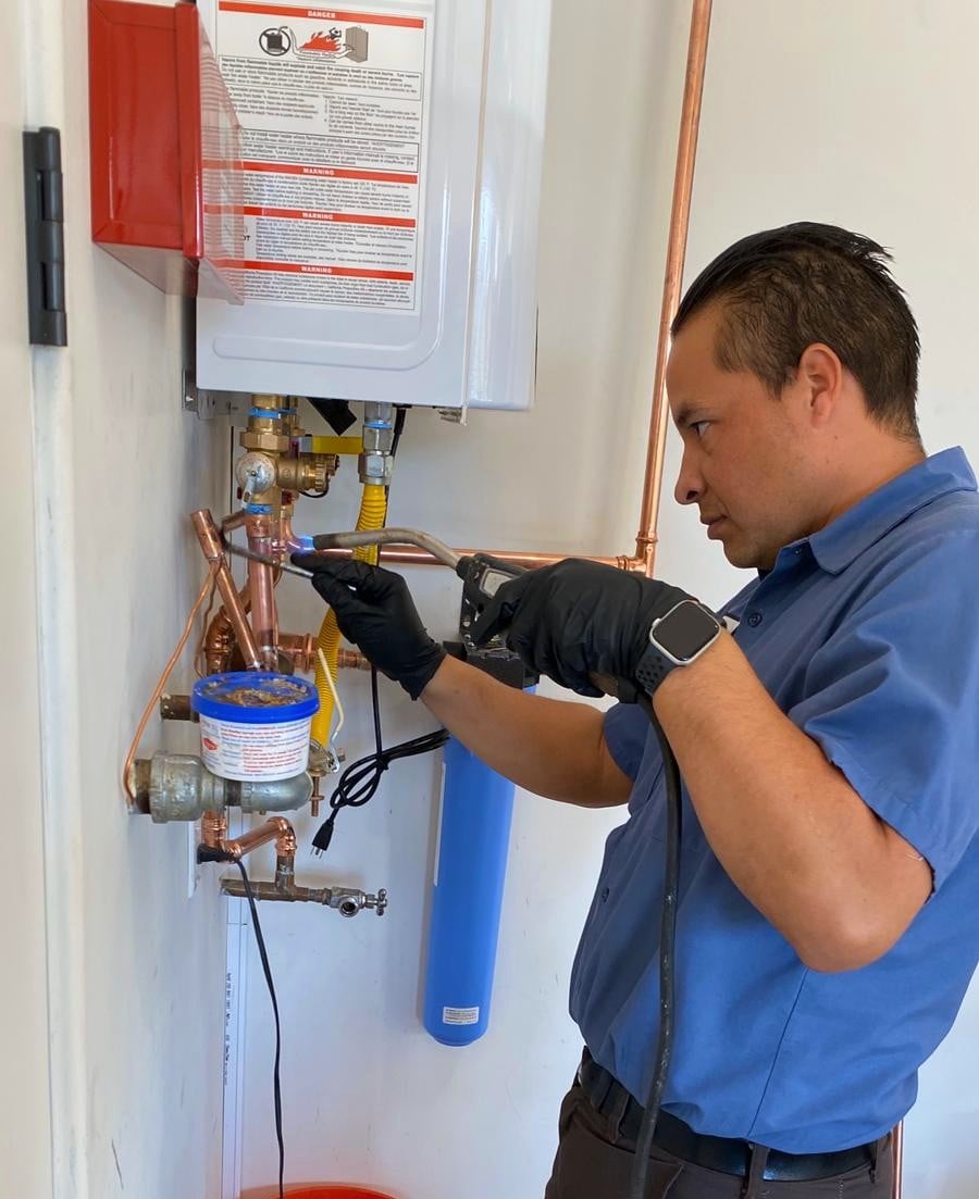 Monkey Wrench Plumbing technician repairing tankless water heater