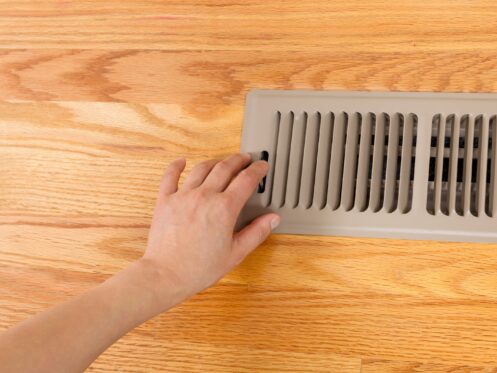 Hand opening up a floor vent
